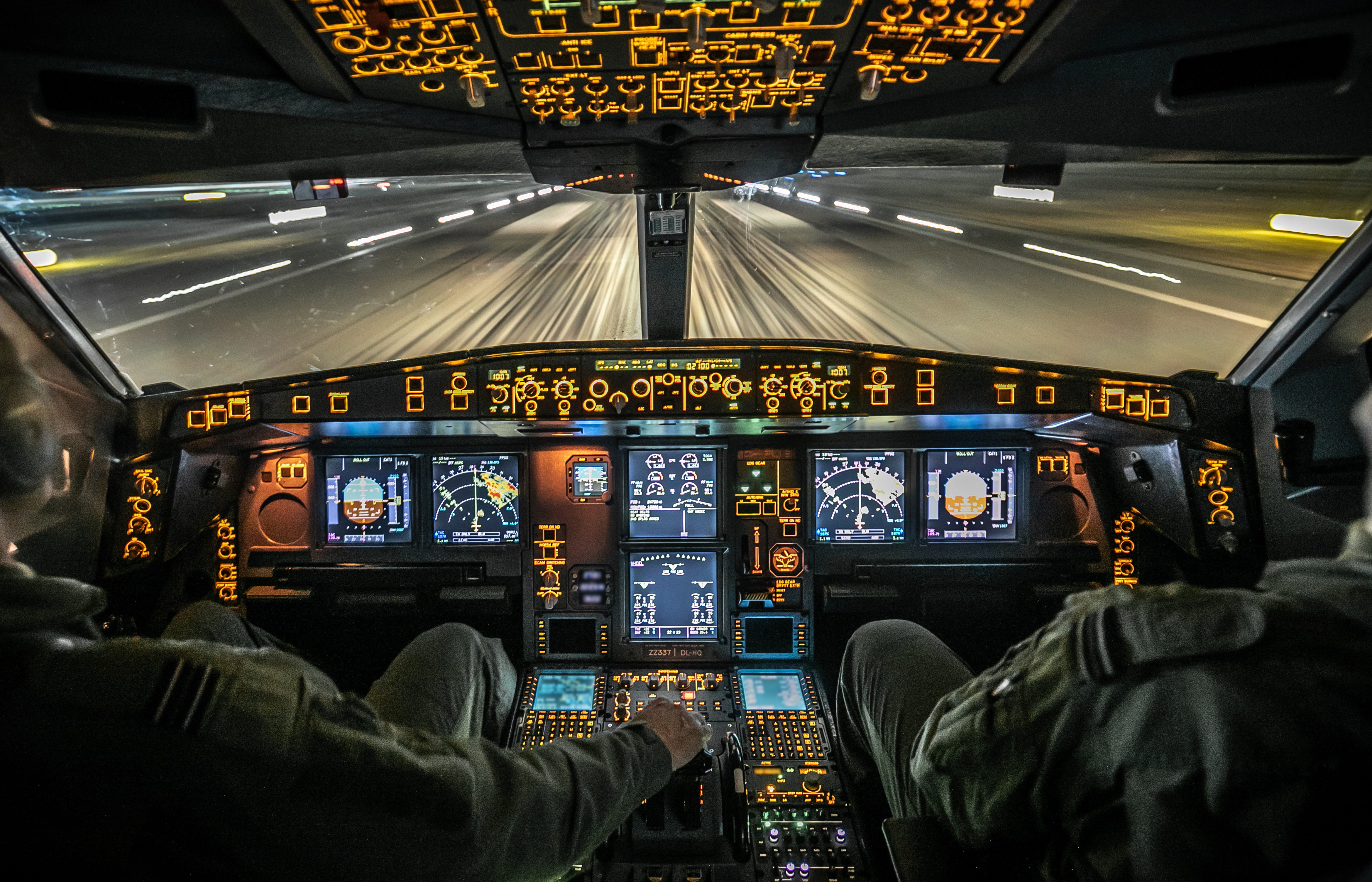 Pilots in the cockpit with bright lights. 